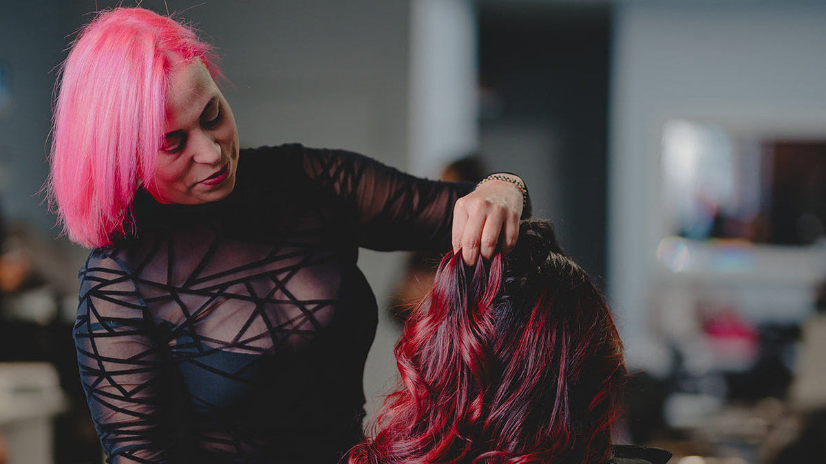 Maribel Aquino working on a client’s vivid red hair color at Divine Beauty Salon in South Amboy NJ